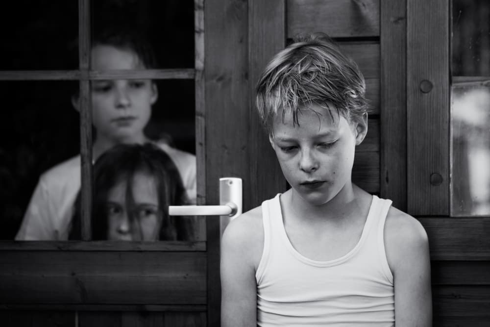Pensive Boy Watching Sisters by Mirjam Delrue — canvas wall art