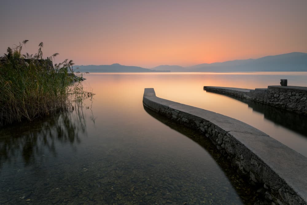 Curved Piers Lake Sunset by Marco Galimberti — canvas wall art