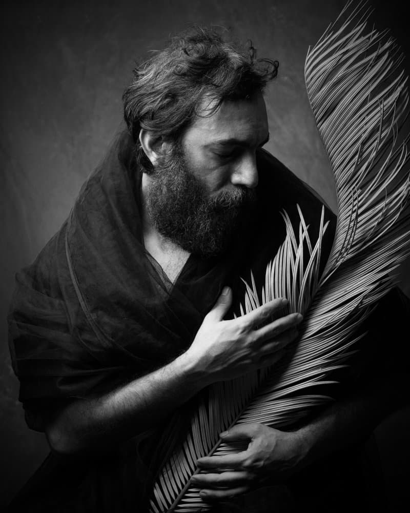 Pensive Man Palm Frond by Mehdi Mokhtari — canvas wall art