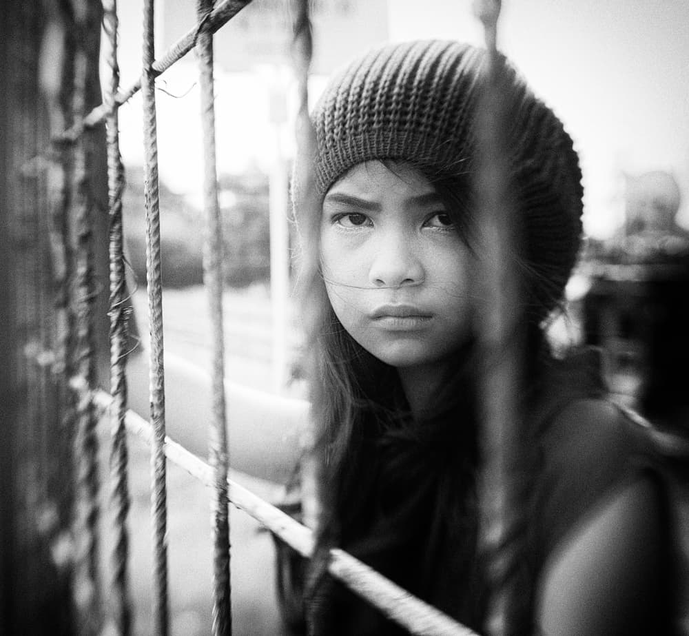 Youthful Gaze Behind Bars by Andi Halil — canvas wall art
