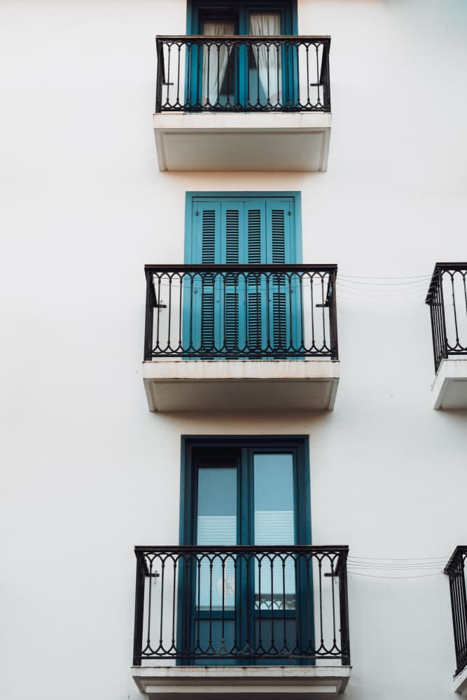 White Building Blue Balconies by Aimee Giles — canvas wall art
