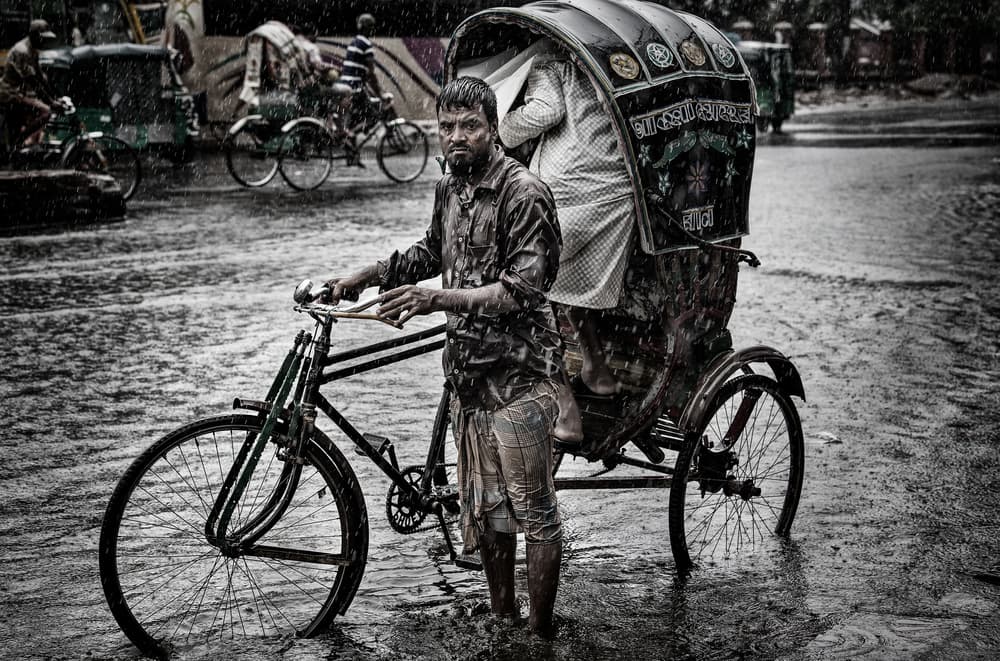 Rickshaw Puller in Rain by Joxe Inazio Kuesta Garmendia — canvas wall art