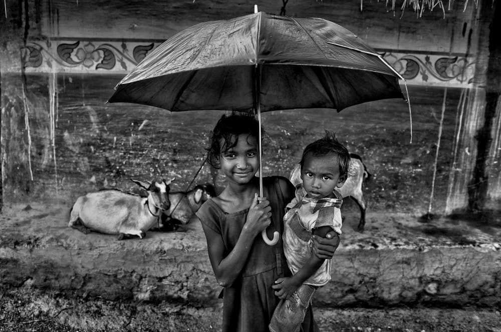 Siblings Under Umbrella by Avishek Das — canvas wall art