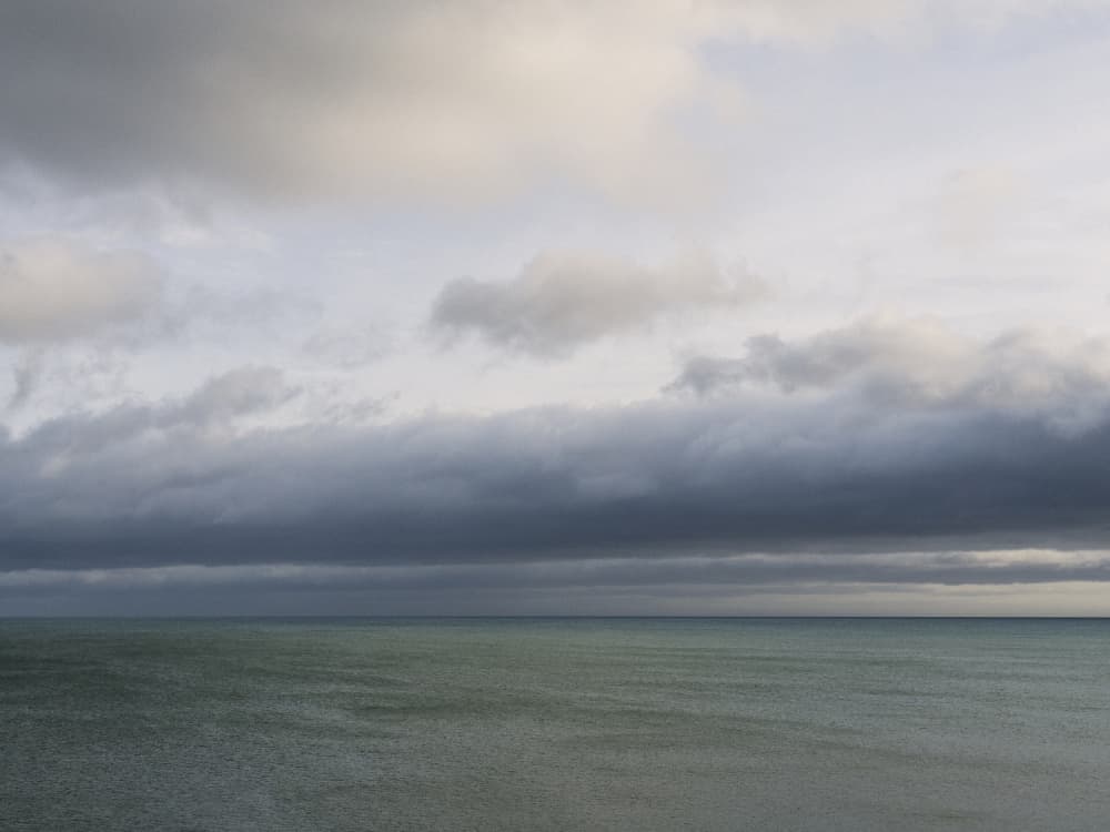 Moody Sky Over Sea by Lynann Colligan — canvas wall art