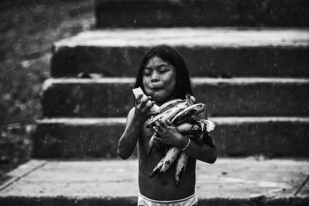 Young Girl Eating Banana by Pavol Stranak — canvas wall art