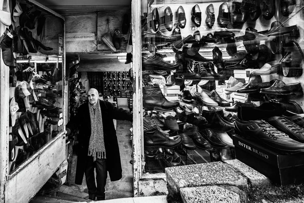 Smiling Shoe Shopkeeper by Yavuz Pancareken — canvas wall art