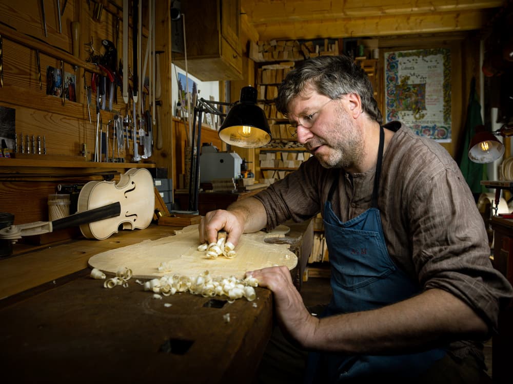 Luthier Crafting Violin by Michael Allmaier — canvas wall art