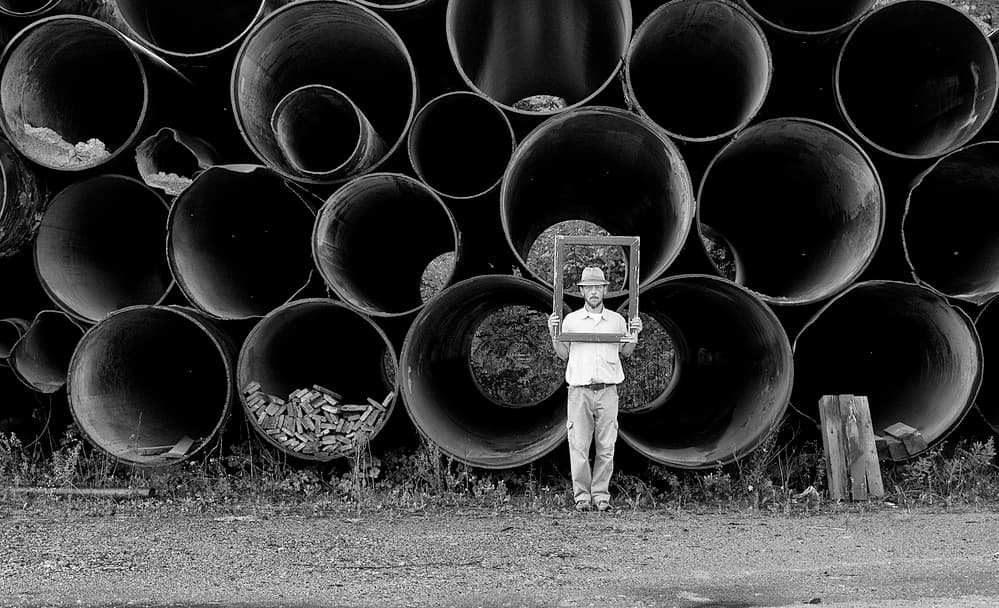 Man Frames Industrial Pipes by Carlo Ferrara — canvas wall art