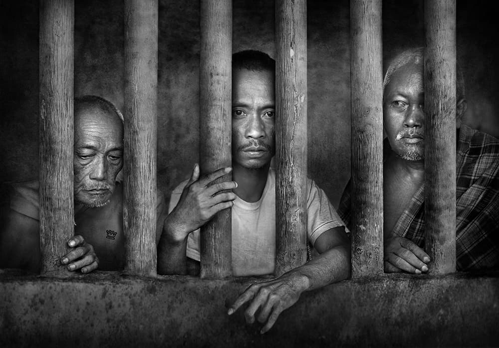 Somber Faces Behind Bars by Sebastian Kisworo — canvas wall art