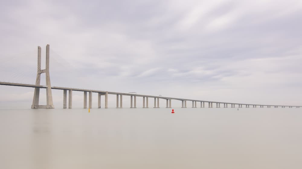 Vast Bridge Over Calm Water by JUAN CARLOS HERVÁS MARTÍNEZ — canvas wall art