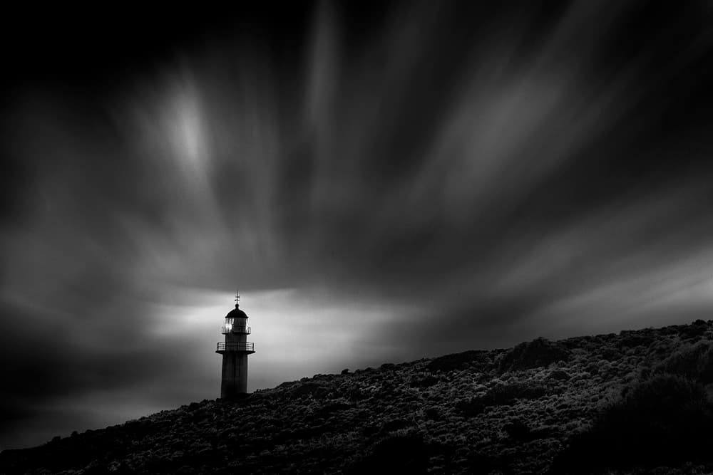 Lighthouse Under Moody Sky by George Digalakis — canvas wall art