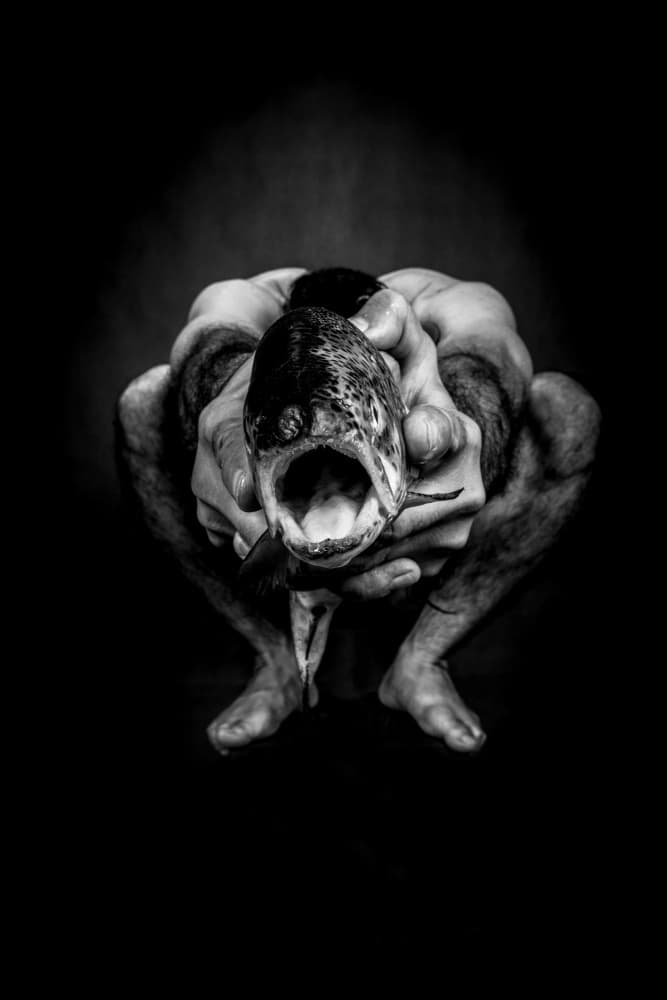 Man Holds Primal Fish by Afshin Saeidinia — canvas wall art