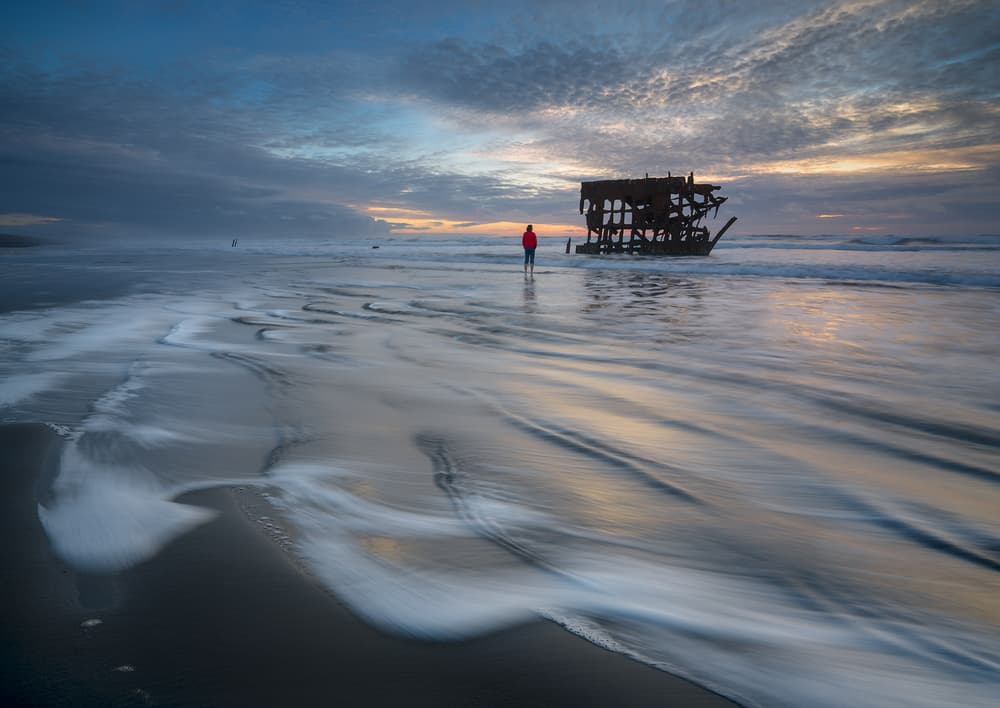 Lone Figure Shipwreck Sunset by Shenshen Dou — canvas wall art