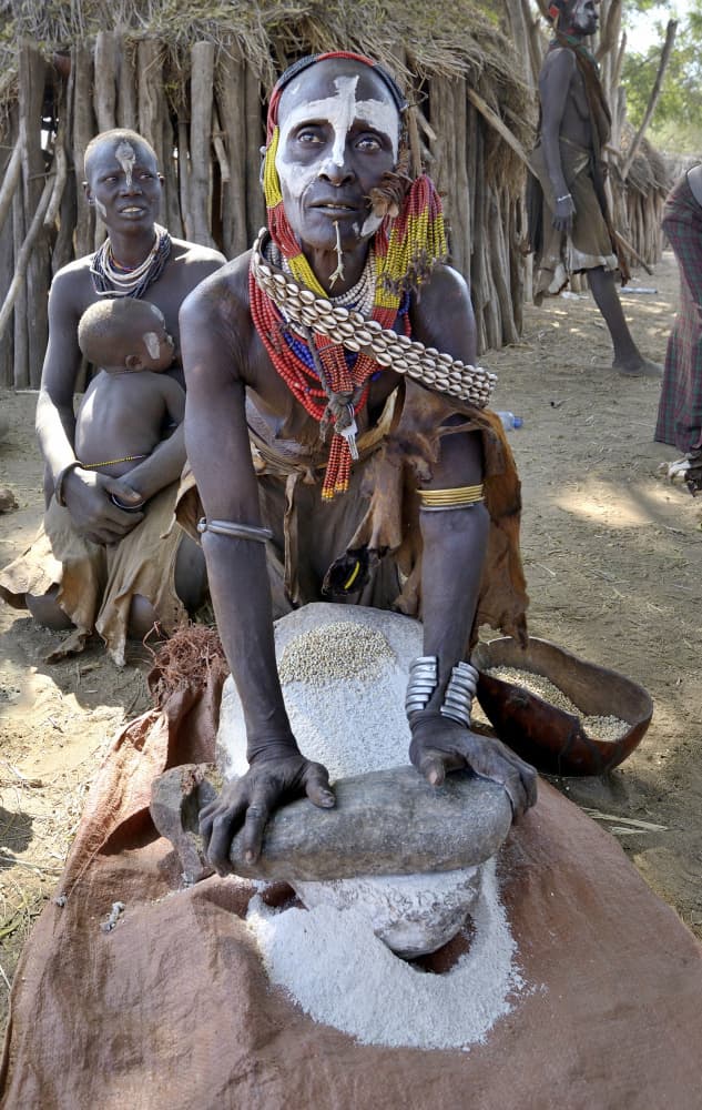 African Woman Grinding Grain by Giuseppe DAmico — canvas wall art