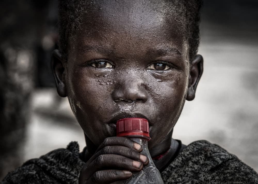 African Boy Drinking by Joxe Inazio Kuesta Garmendia — canvas wall art