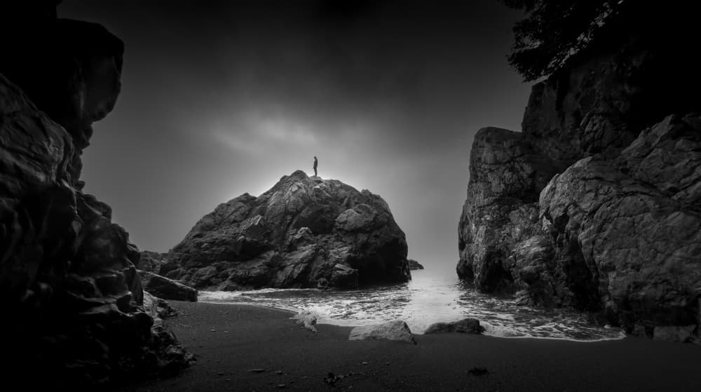 Solitary Figure on Coastal Rock by Bing Li — canvas wall art
