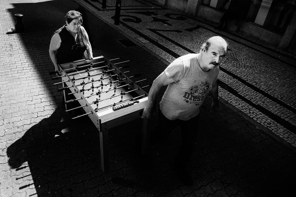Two People Carrying Foosball by Jure Kravanja — canvas wall art