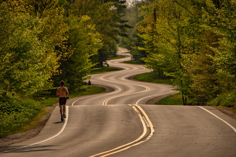 Runner Winding Forest Road by Marek Lapa — canvas wall art