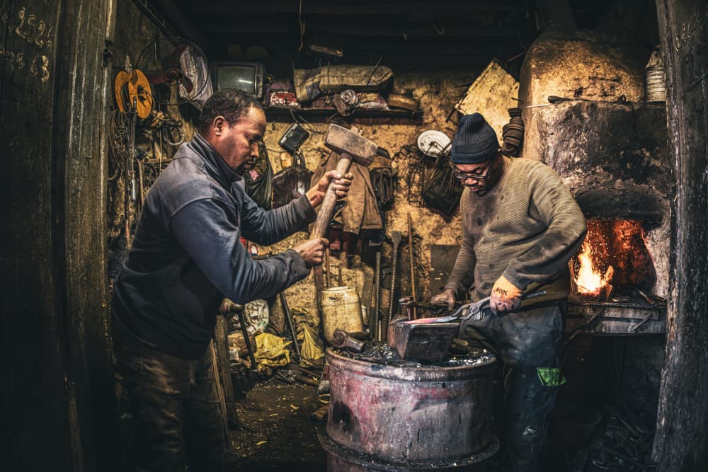 Blacksmiths Hammering Metal by Marco Tagliarino — canvas wall art