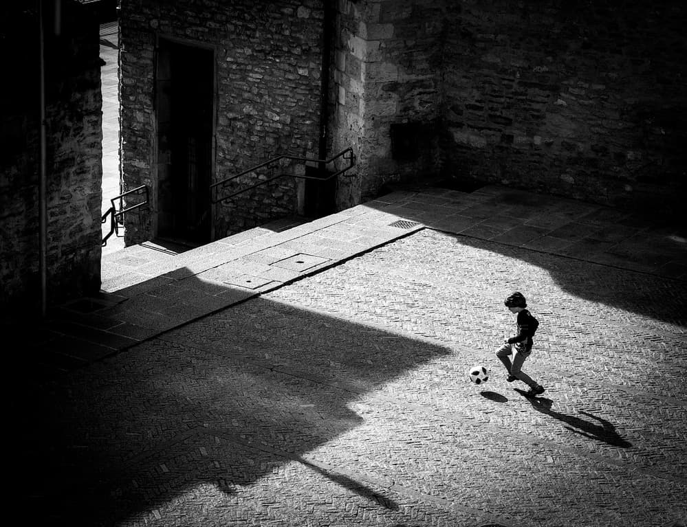 Boy Playing Shadow Soccer by Adolfo Urrutia — canvas wall art