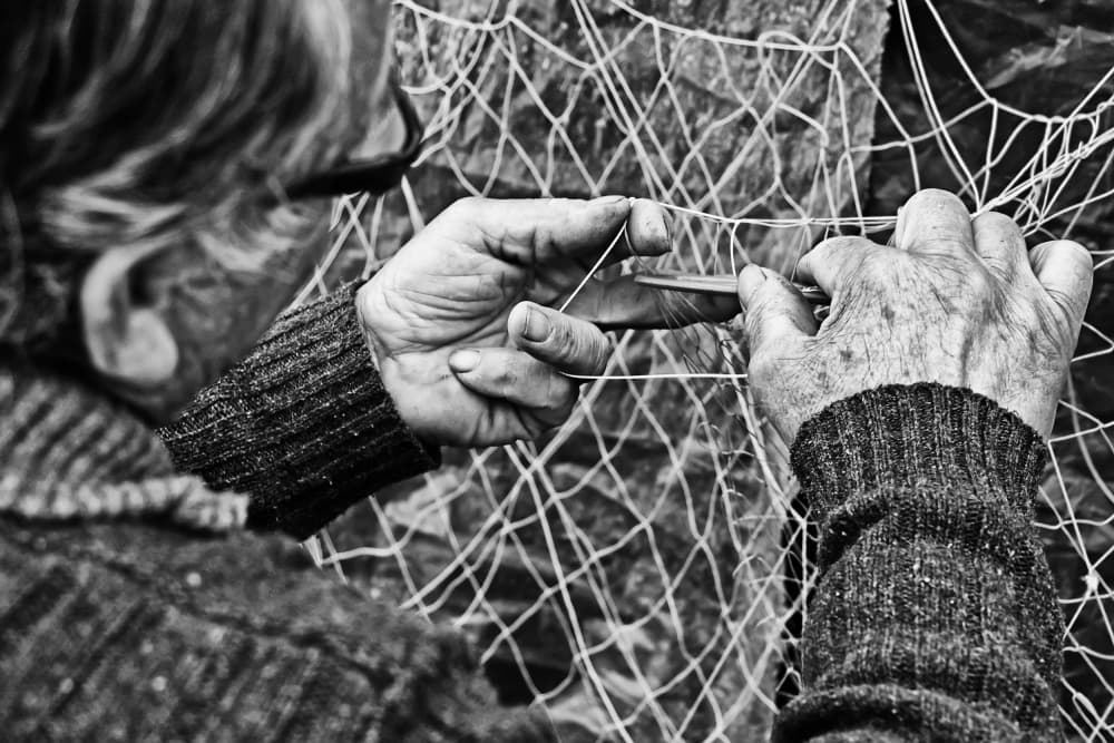 Skilled Hands Mending Net by Josefina Melo — canvas wall art