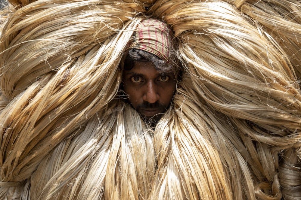 Man Carrying Jute by Azim Khan Ronnie — canvas wall art