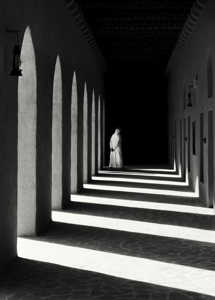 Solitary Figure Arched Hallway by Karim Al Thahaby — canvas wall art