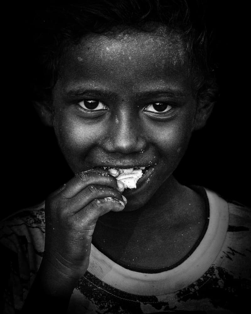 Joyful Child Eating by Kuntal Biswas — canvas wall art