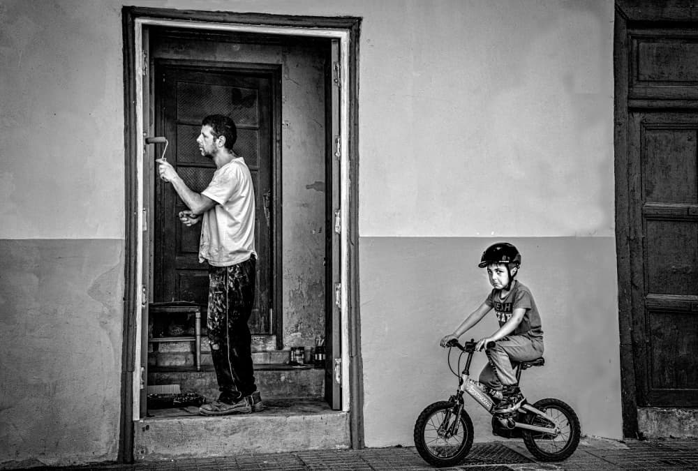 Man Painting Boy Riding by Montserrat Alviani — canvas wall art