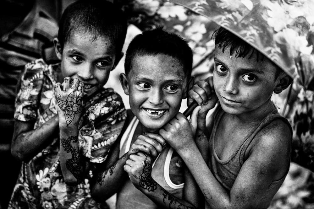 Joyful Children Under Umbrella by Joxe Inazio Kuesta Garmendia — canvas wall art