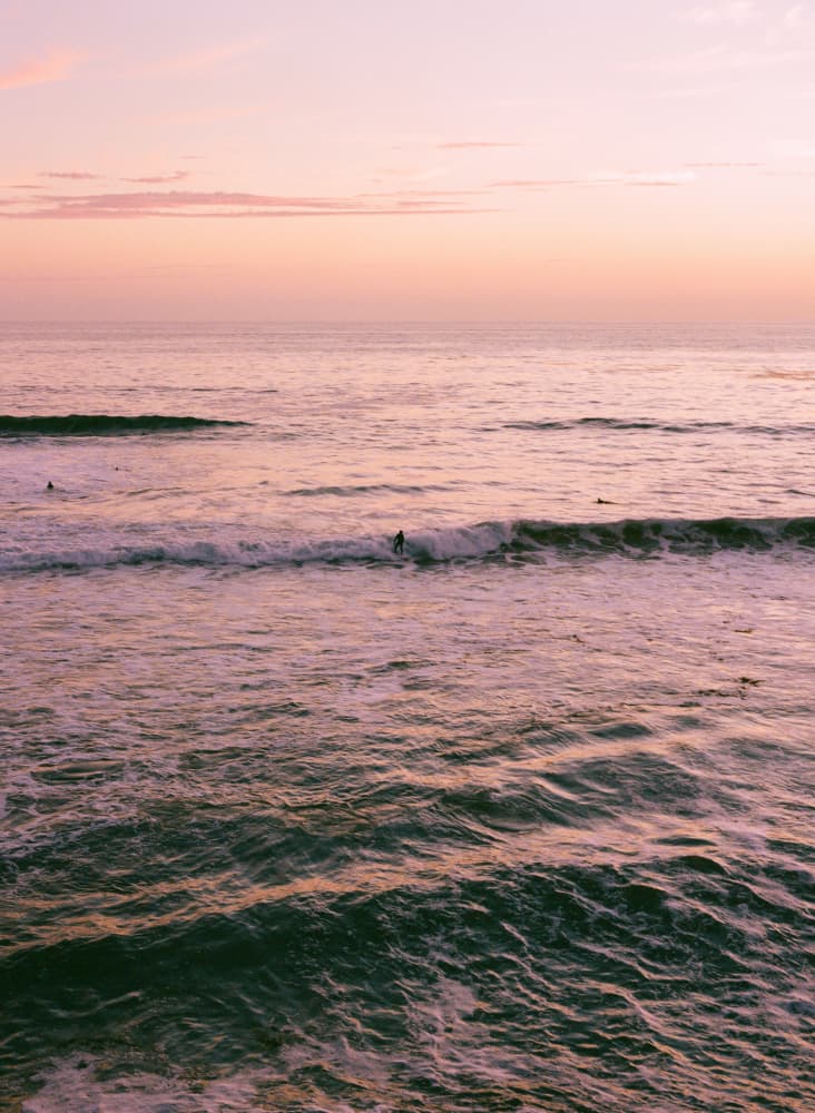 Pink Sunset Surfers by Bethany Young — canvas wall art
