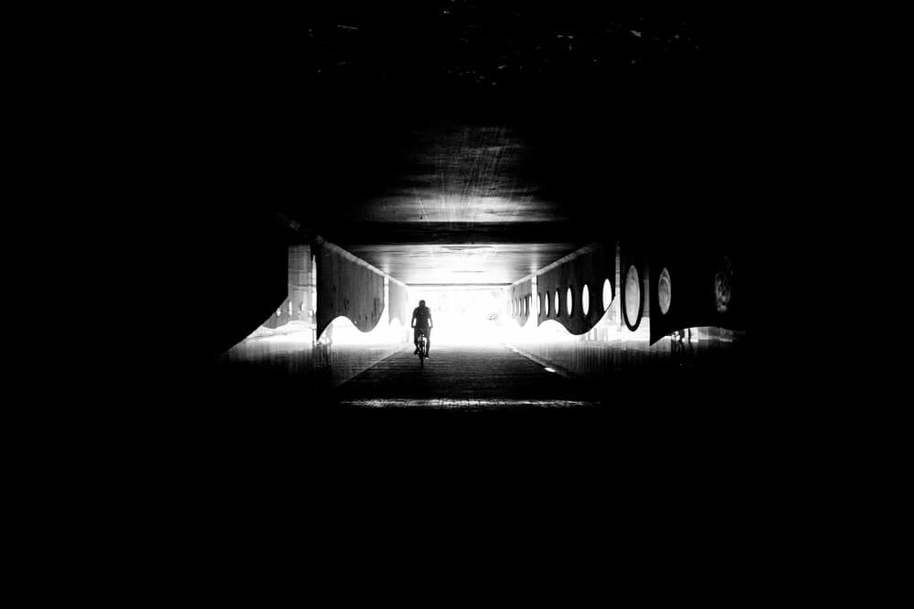 Lone Cyclist Tunnel Light by Justyna Jaszke — canvas wall art