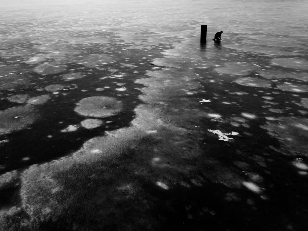 Lone Figure on Frozen Water by Leszek Paradowski — canvas wall art