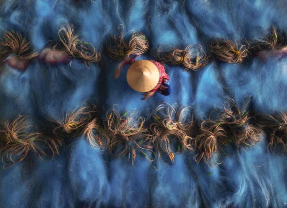 Worker Drying Blue Nets by Nguyen Tan Tuan — canvas wall art