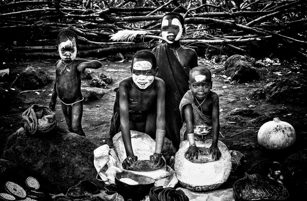 African Children Grinding by Joxe Inazio Kuesta Garmendia — canvas wall art