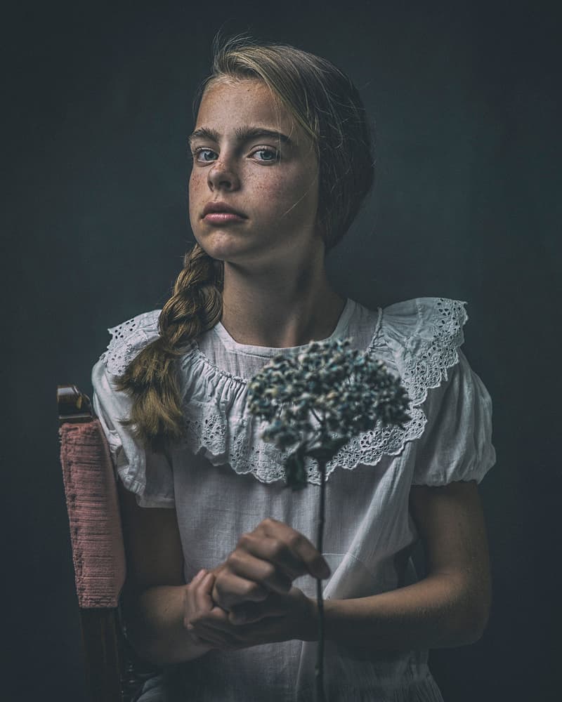 Pensive Girl Holding Flower by Ewa Cwikla — canvas wall art