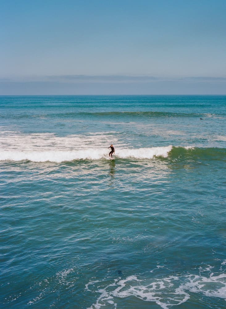 Surfer On Blue Ocean by Bethany Young — canvas wall art