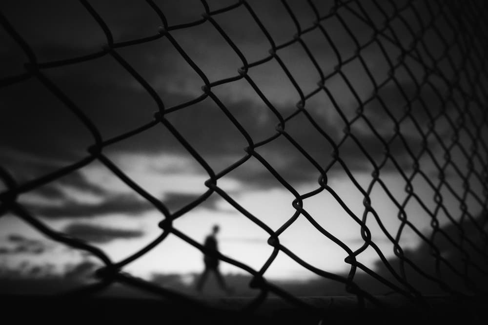Solitary Figure Beyond Fence by Ali Ayer — canvas wall art