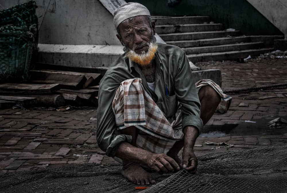 Orange Bearded Fisherman Mending Net by Joxe Inazio Kuesta Garmendia — canvas wall art
