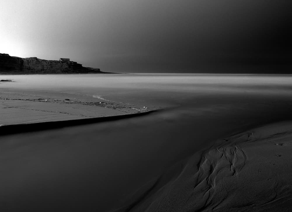 Dramatic Black and White Beach by Nana Sousa Dias — canvas wall art