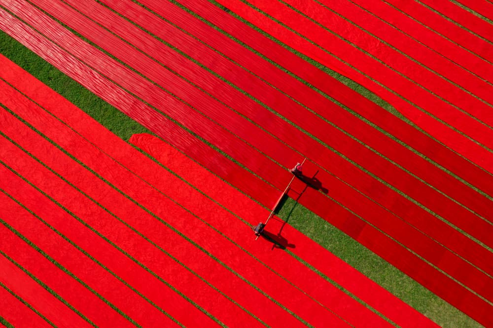 Red Fabric Drying Field by Azim Khan Ronnie — canvas wall art