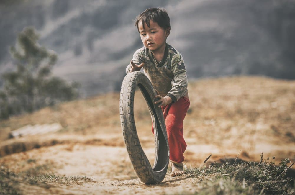 Young Boy Tire Play by Milton Louiz — canvas wall art
