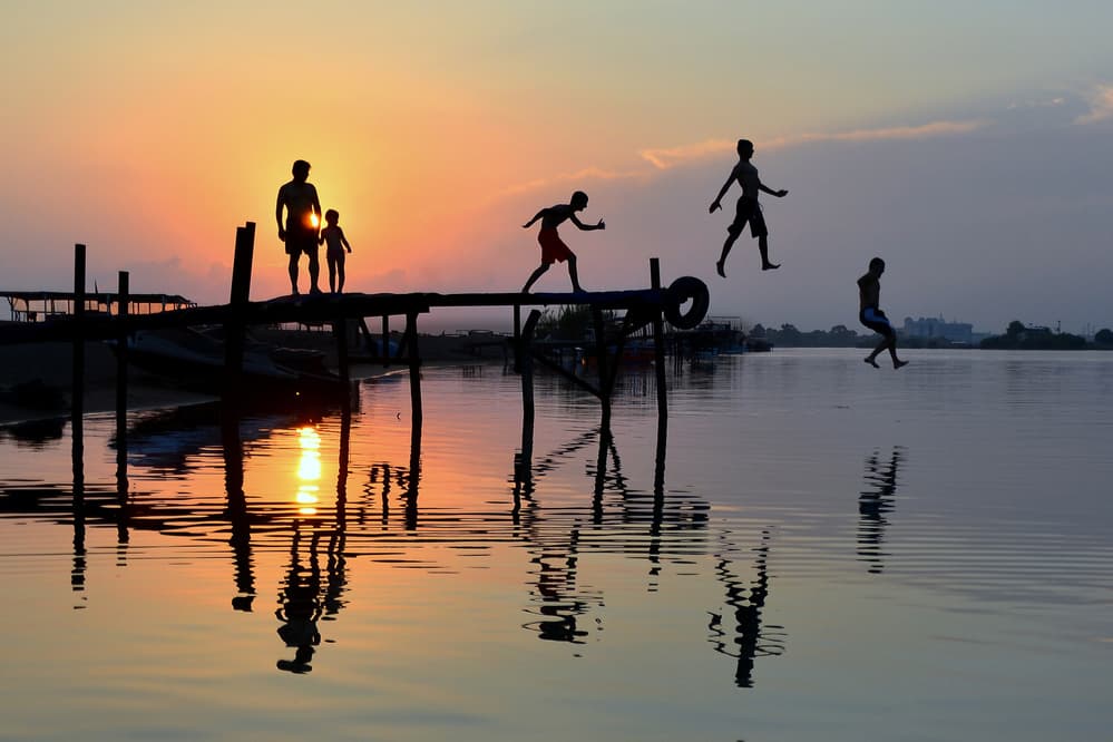 Kids Jumping Sunset by Ali Can — canvas wall art