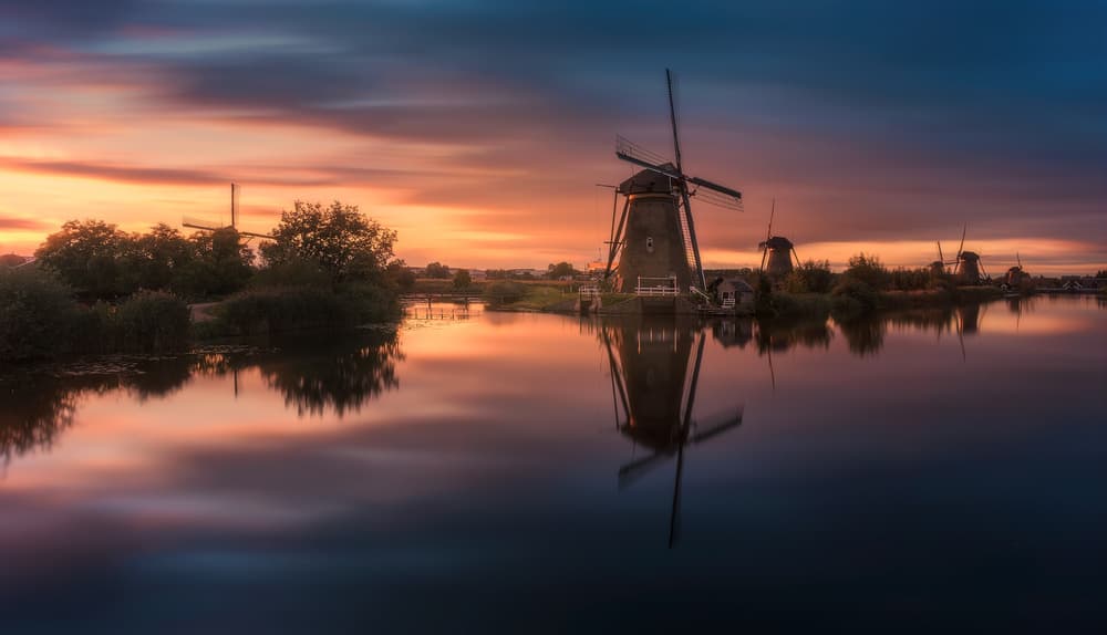 Dutch Windmills Sunset Reflection by Javier de la Torre — canvas wall art