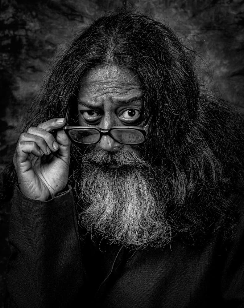 Man Looking Over Glasses by DEBASISH CHATTOPADHYAY — canvas wall art