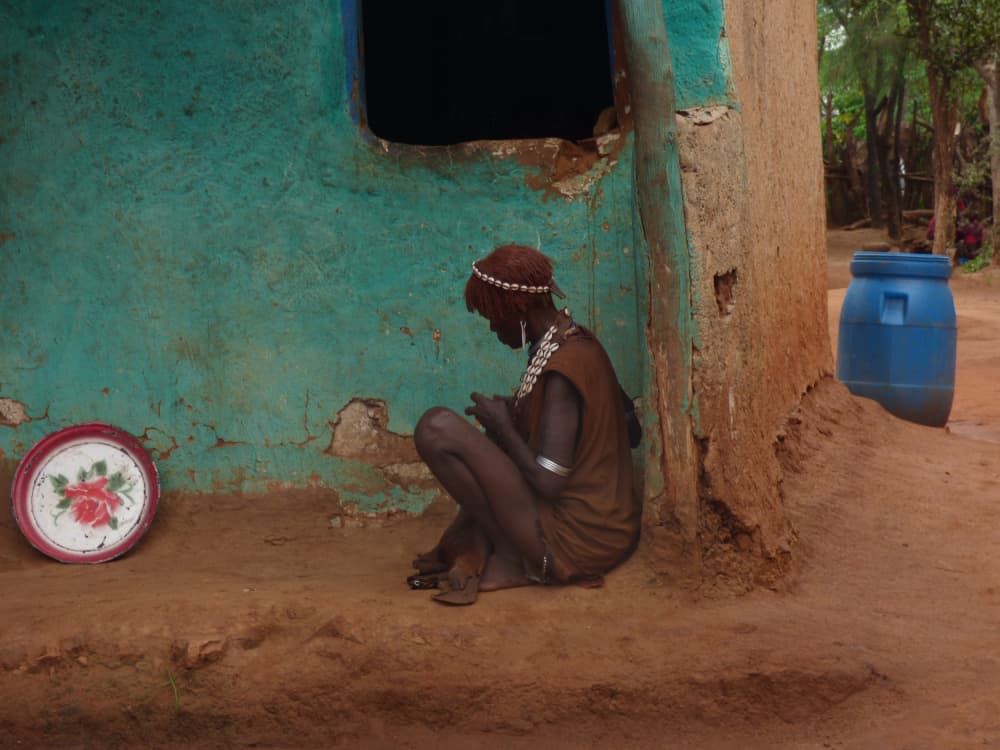 African Woman By Hut by Ilana Lam — canvas wall art