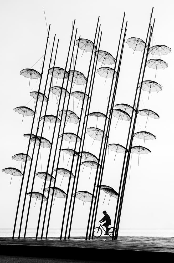 Cyclist Under Umbrellas by George Digalakis — canvas wall art