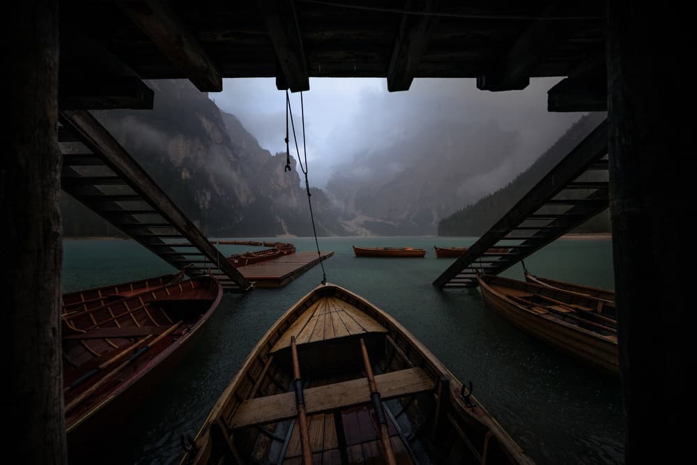 Moody Mountain Lake Boats by Marco Tagliarino — canvas wall art
