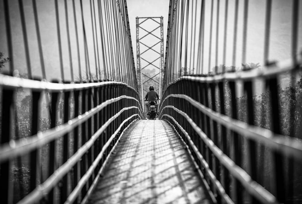 Lone Rider Crossing Bridge by Marco Tagliarino — canvas wall art