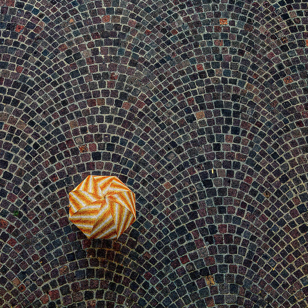 Orange Origami on Cobblestones by Massimo Della Latta — canvas wall art